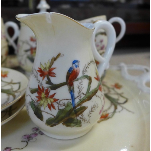 794E - A continental four setting tea set decorated with flora and fauna, parrots and butterflies, with tra... 