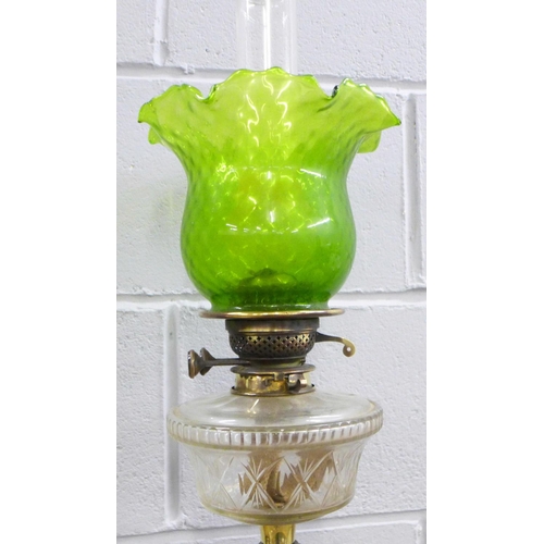 813 - An oil lamp with green glass shade and a glass bell dome