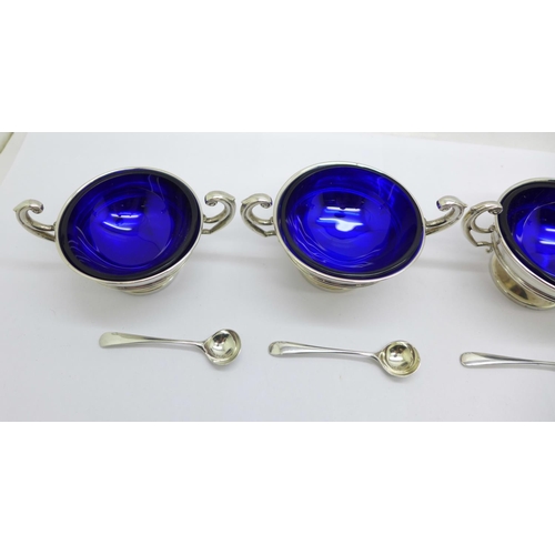 850 - A set of four silver salts with blue glass liners, Birmingham 1907, the spoons hallmarked London 190... 