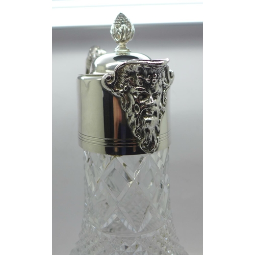 860 - A white metal mounted glass claret jug, marked 999 on the handle and lid