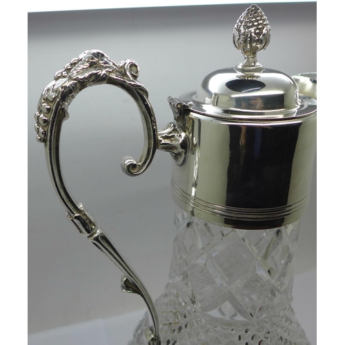 860 - A white metal mounted glass claret jug, marked 999 on the handle and lid