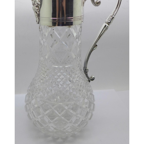 860 - A white metal mounted glass claret jug, marked 999 on the handle and lid