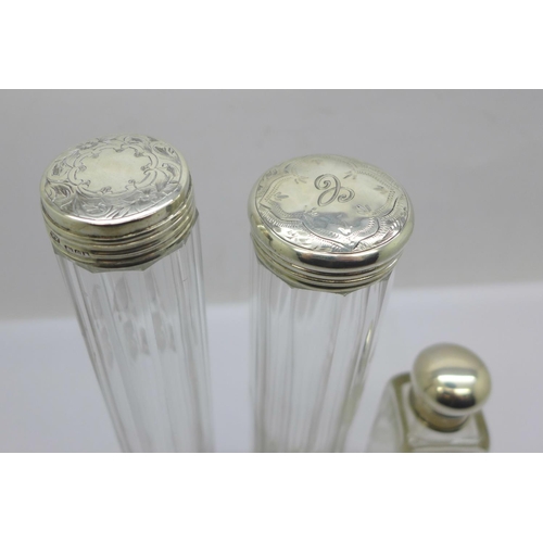 882 - A silver topped glass scent bottle and two silver topped glass bottles, glass chipped on rim of one ... 