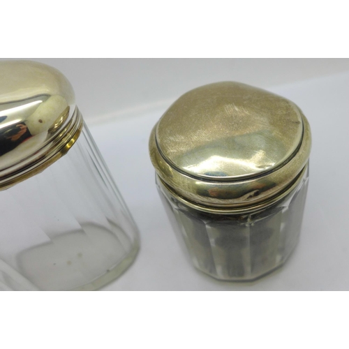 887 - Three silver topped glass jars including one Victorian, 64g of silver, tops dented