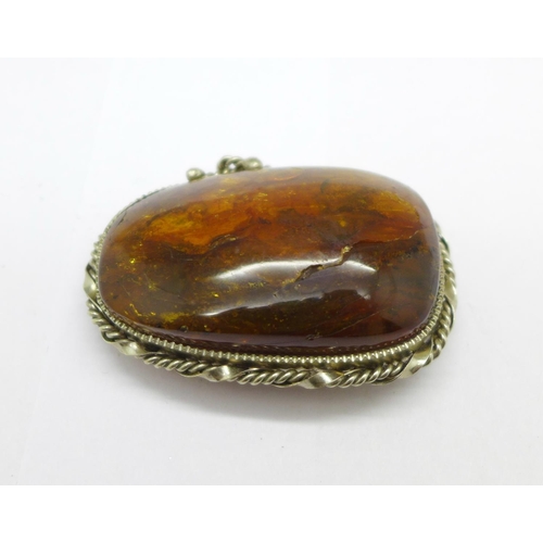 974 - An amber brooch, (mount tests as silver)