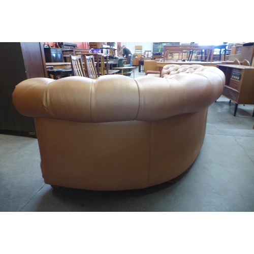 100 - A buttoned faux leather copper coloured demi lune settee