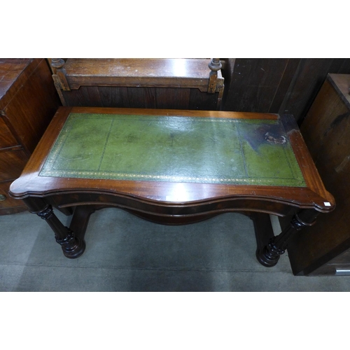 203 - A Victorian mahogany and green leather topped serpentine writing table