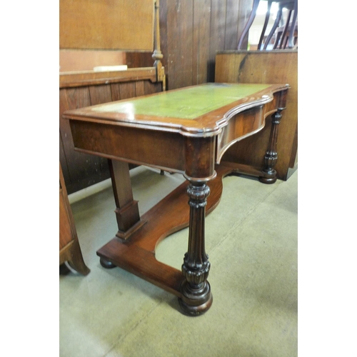 203 - A Victorian mahogany and green leather topped serpentine writing table