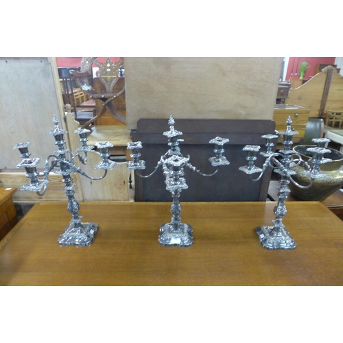 396 - A set of three plated candelabra