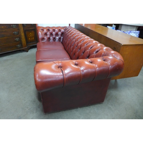 93 - A red leather Chesterfield settee