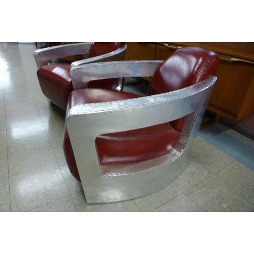 102 - A pair of riveted aluminium and red leather aviator chairs