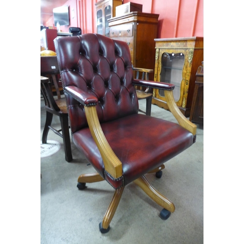89 - A beech and red leather revolving desk chair