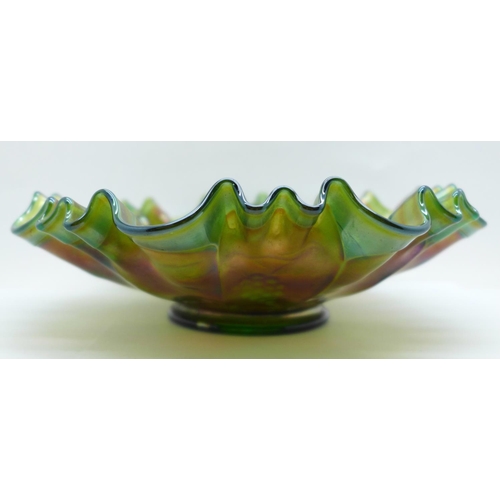 621 - A green carnival glass dish with wavy edge and grape design, 21.5cm