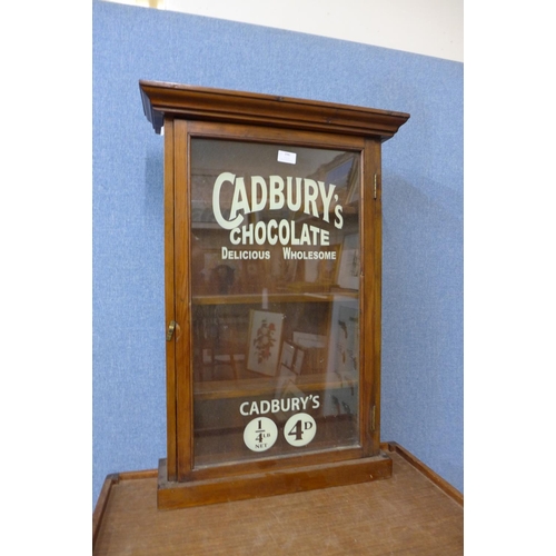 396 - An early 20th Century pine wall hanging display cabinet, bearing later Cadbury's Chocolate inscripti... 