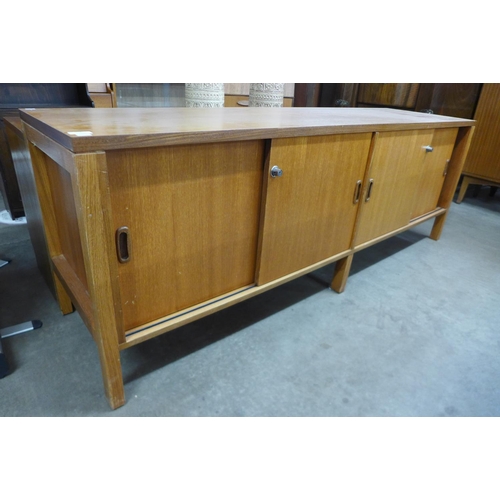 117A - A teak sliding two door sideboard