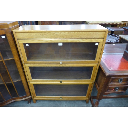 132 - An oak three tier sectional stacking bookcase