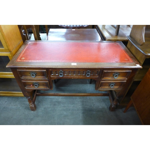 134 - An oak and red leather topped writing desk