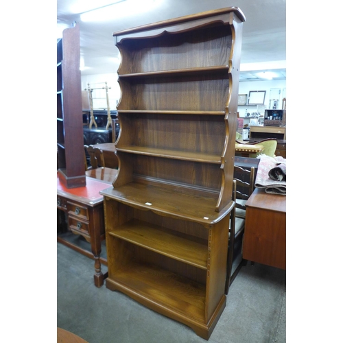 135 - An Ercol Golden Dawn elm open bookcase