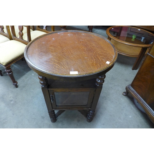 26 - An early 20th Century oak circular bobbin display table