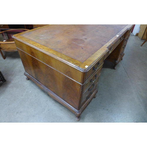 29 - A George III style walnut and leather topped library desk