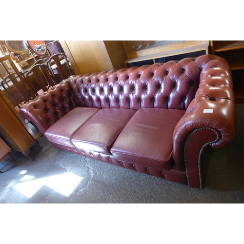 30 - A red leather Chesterfield settee