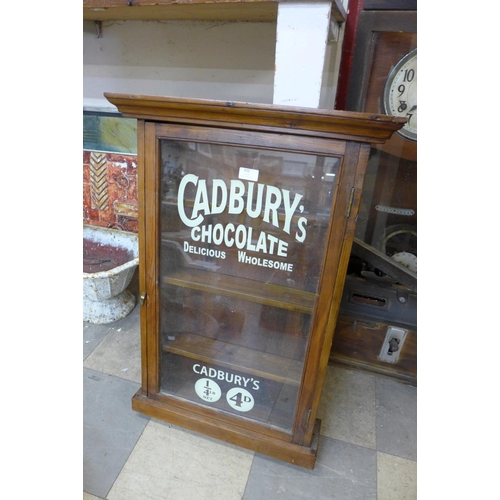 435 - An early 20th Century pine wall hanging display cabinet, bearing later Cadbury's Chocolate inscripti... 