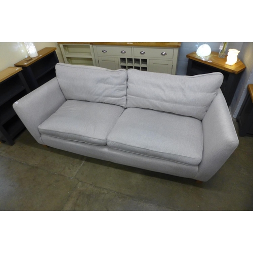 1312 - An oatmeal upholstered three seater sofa (ex display)