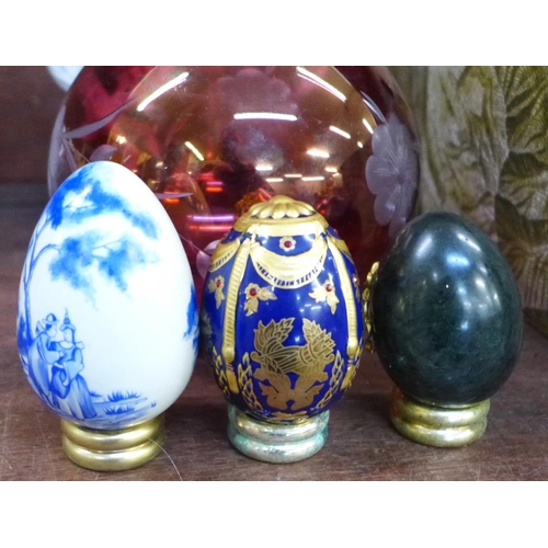 690 - A collection of Thailand and other decorative eggs in a tray, a cranberry glass bowl and a Franklin ... 