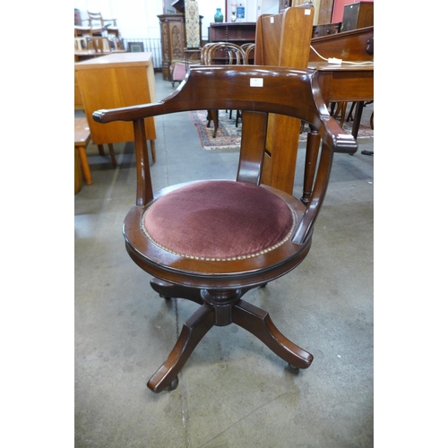 40 - A mahogany and fabric seated revolving desk chair