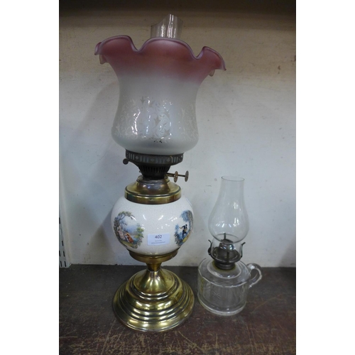 402 - Two oil lamps, one with pink edged glass shade