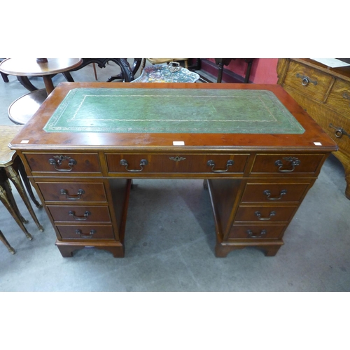 9 - A yew wood and green leather topped pedestal desk