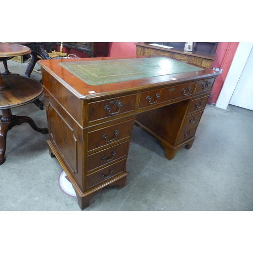 9 - A yew wood and green leather topped pedestal desk