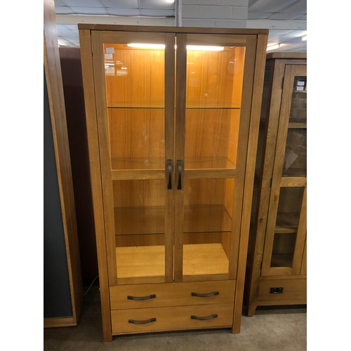 1309 - An oak two door, two drawer illuminated display cabinet (odd mark)