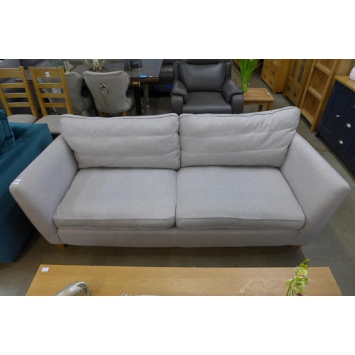 1312 - An oatmeal upholstered three seater sofa (ex display)