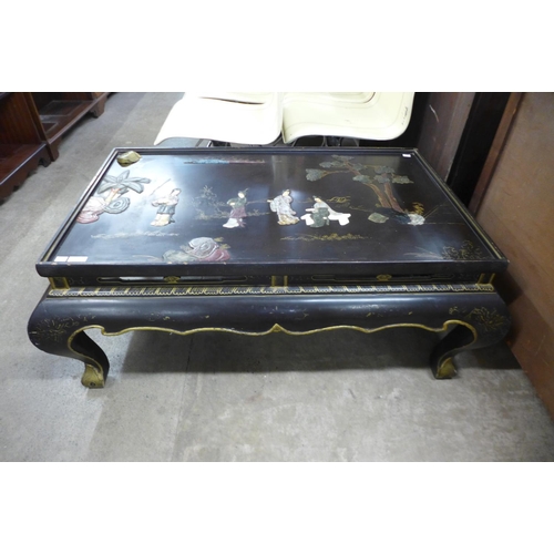 137 - An oriental chinoiserie ebonised coffee table (lacking glass )