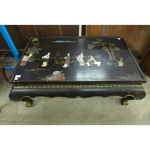 137 - An oriental chinoiserie ebonised coffee table (lacking glass )