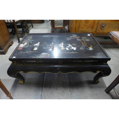 137 - An oriental chinoiserie ebonised coffee table (lacking glass )