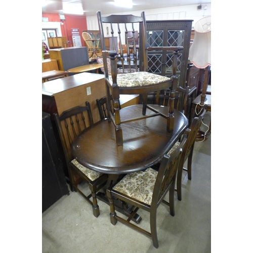 183 - An oak extending dining table, six chairs and a corner cabinet