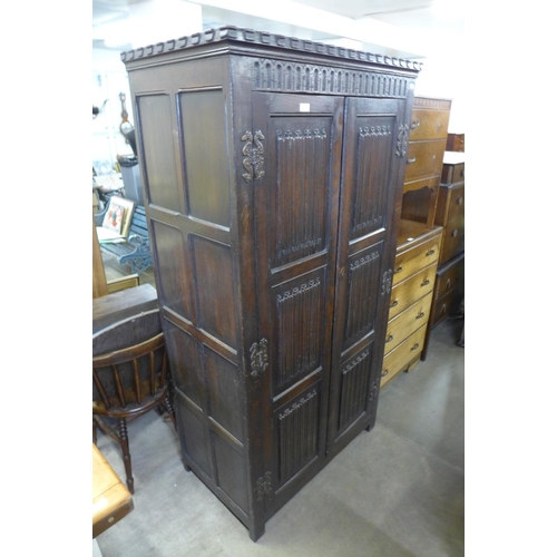 210 - A carved oak linenfold panel wardrobe