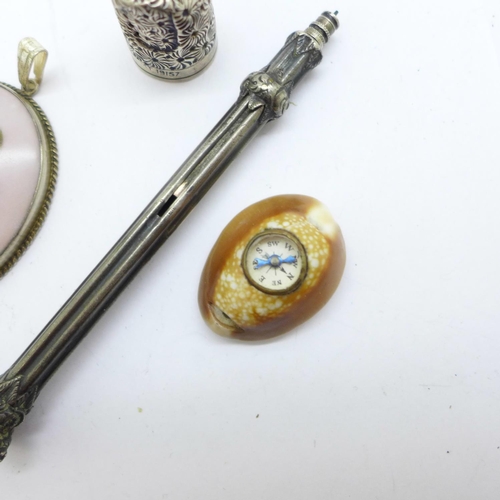 1029 - A silver mounted portrait pendant, a novelty compass mounted shell, a hallmarked silver thimble, a/f... 