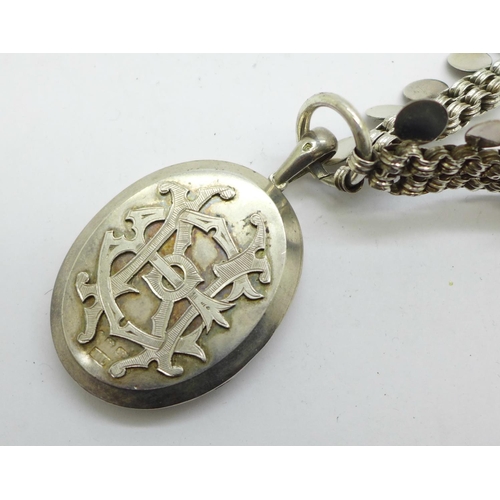 1037 - A hallmarked Victorian silver locket with monogram and pierced decoration, worn Birmingham date lett... 