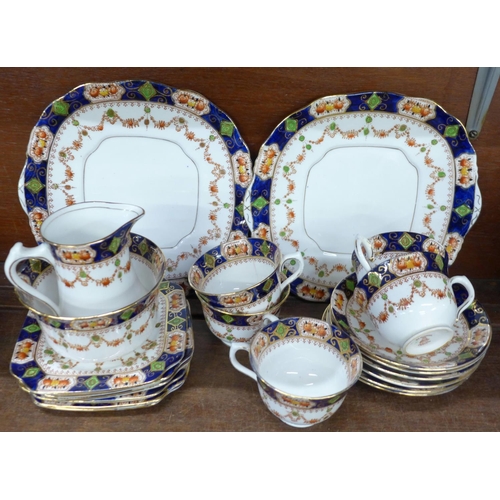 711 - A six setting china tea service, five cups, six saucers, side plates, two cake plates, sugar and cre... 