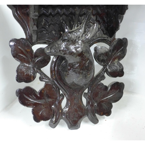 745 - A Black Forest carved seated bear and three carved shelves