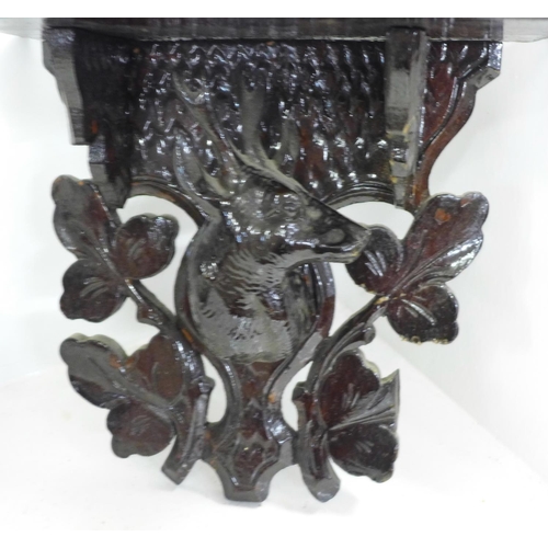 745 - A Black Forest carved seated bear and three carved shelves