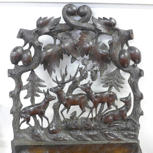 745 - A Black Forest carved seated bear and three carved shelves