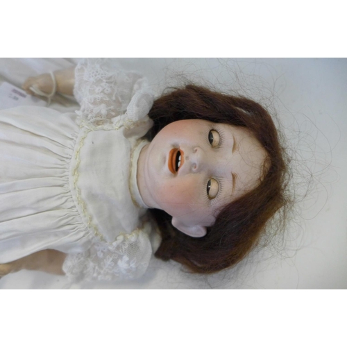 822 - A German Hertel Schwab bisque head doll with brown sleep eyes, 152-2 identification marks, circa 191... 