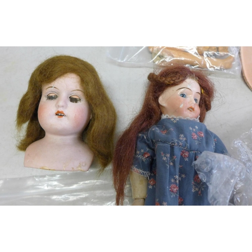 835 - A small box of mixed bisque and composition doll body parts including a German E&S head