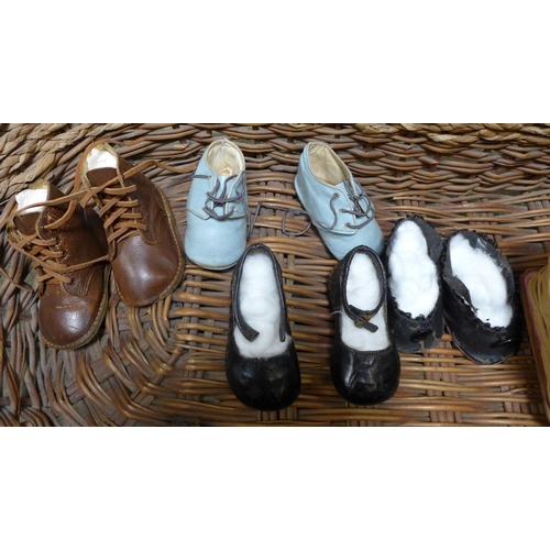 841 - A baby's wicker crib, a toy wicker crib and four pairs of baby's shoes