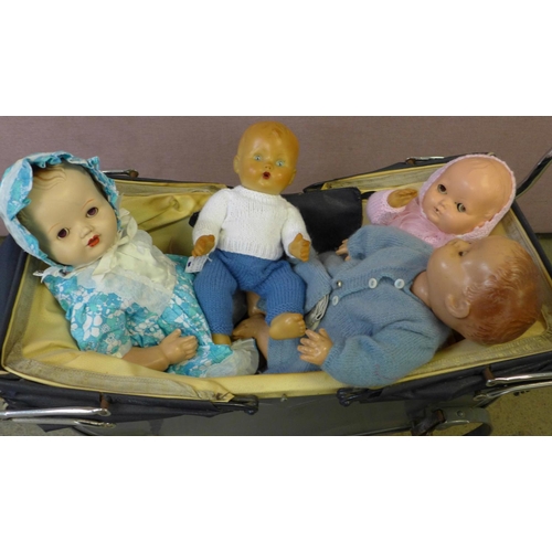 844 - A Palitoy early hard plastic doll, circa 1930-1948, three other dolls and a Tri-ang doll's pram