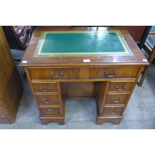 102 - A small yew wood and green leather topped kneehole desk